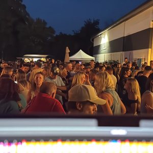 Publikum feiert bei einer Veranstaltung am DJ Trailer