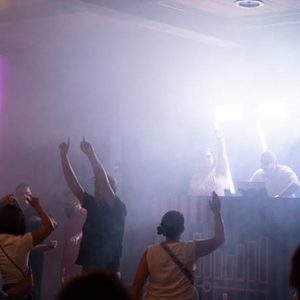 DJ am Mischpult mit grünem Licht