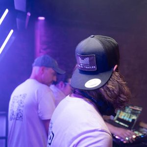 Zwei DJs am Mischpult im blau-violetten Licht